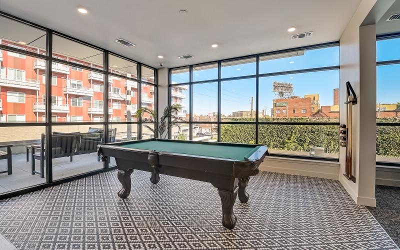 a pool table in a room with a large window
