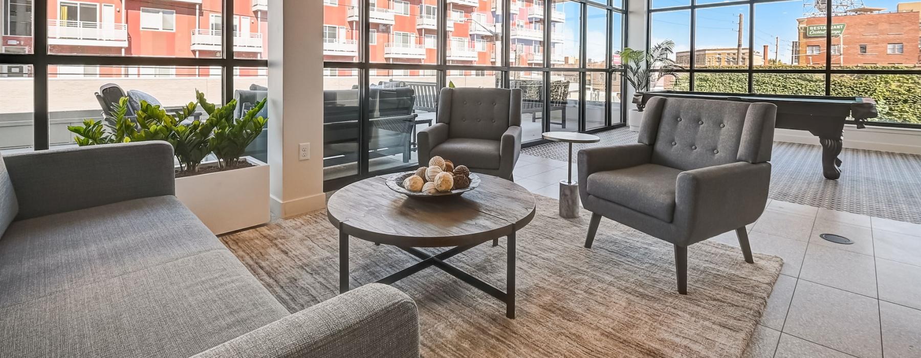 room with a table, chairs surrounded by large windows with neighborhood views